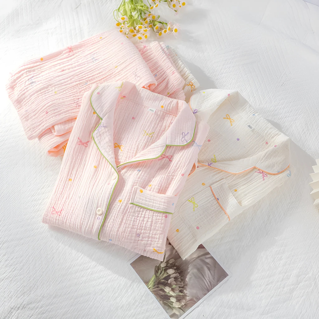 Women's pink cotton pajama set with long sleeves and trousers, laid flat.