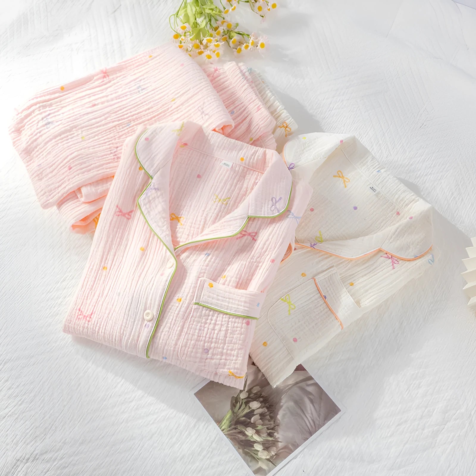 Women's pink cotton pajama set with long sleeves and trousers, laid flat.