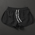 Man wearing loose orange red polyester beach shorts with micro elastic waist