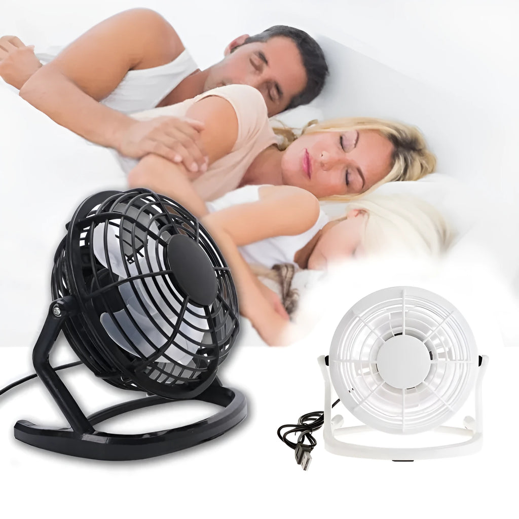 Black mini USB desk fan with adjustable angle on a wooden desk.