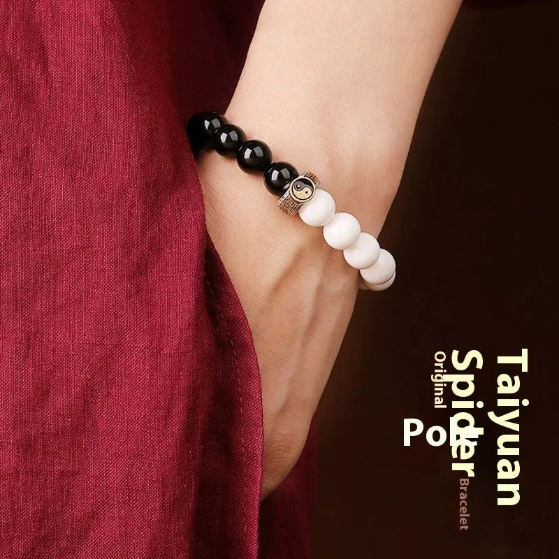 Black obsidian Taiji bracelet with white woven yin-yang symbol and mantra.