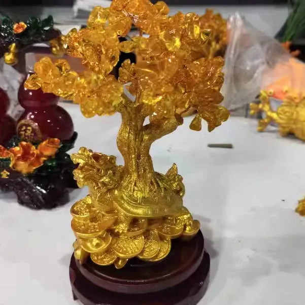 Citrine coloured resin turtle money tree Chinese style ornament on display.