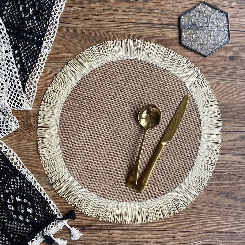 Handwoven round jute placemat with tassel edge in original hemp colour on a wooden table