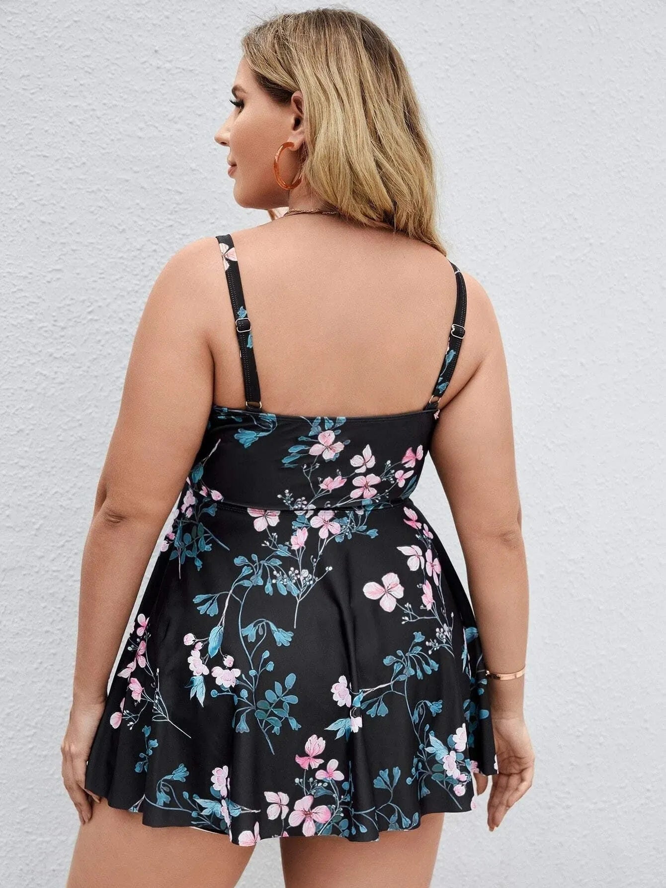 Women's floral print one-piece swimsuit on a hanger, showing split colour design and available in sizes 0XL to 4XL.