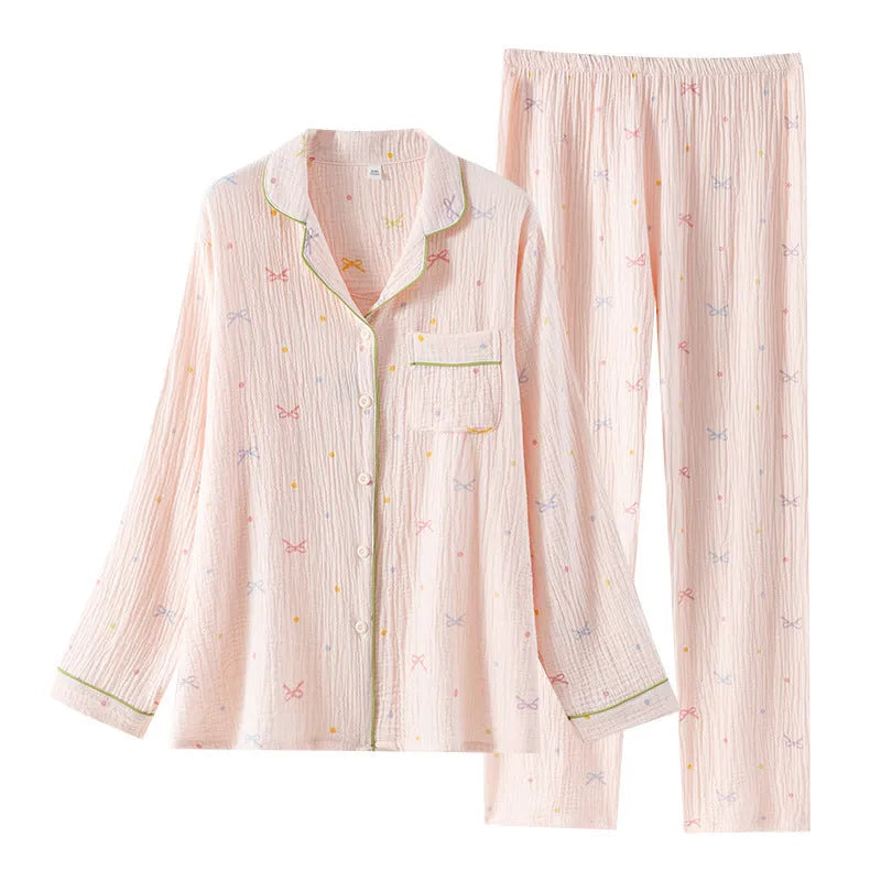 Women's pink cotton pajama set with long sleeves and trousers, laid flat.