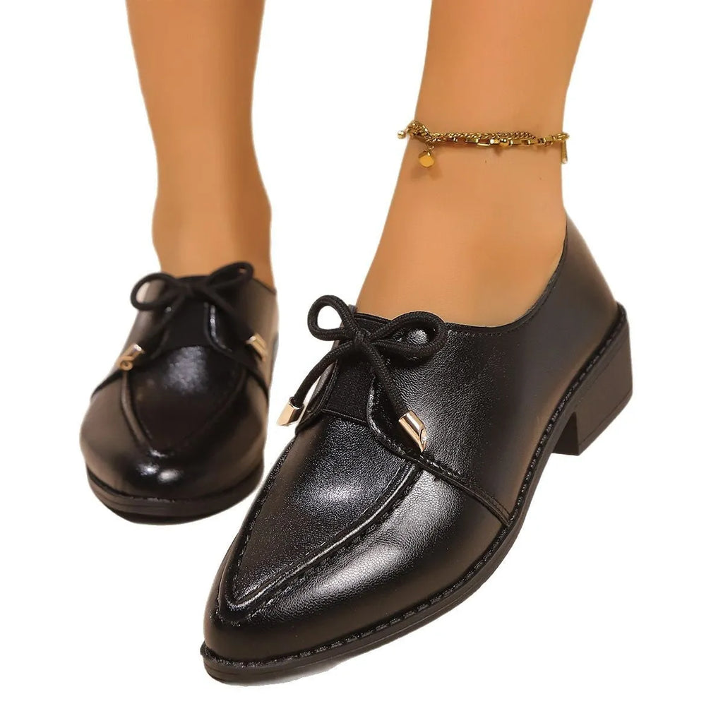 Women's pointed-toe PU slip-on shoe with a decorative bow on a rubber sole.