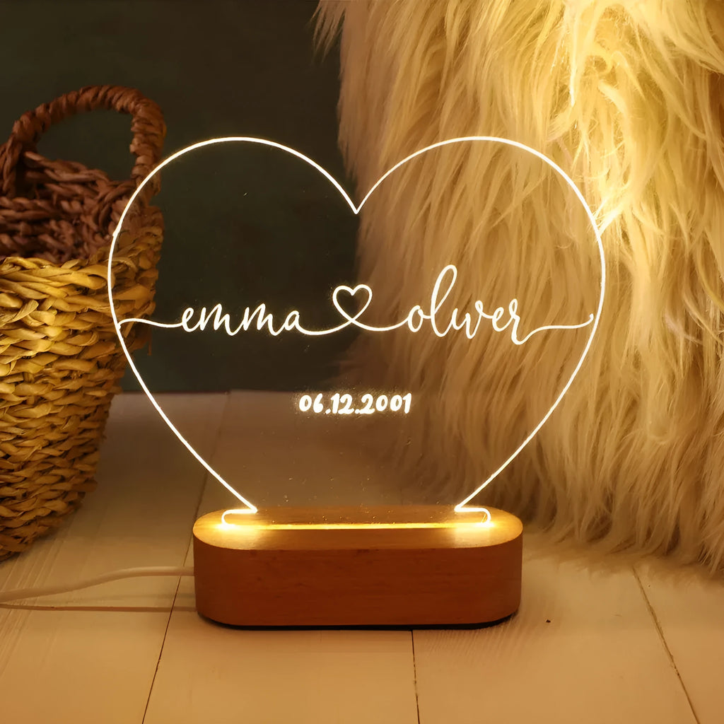Custom transparent acrylic night light with personalised text, lit by LED, on a bedside table.