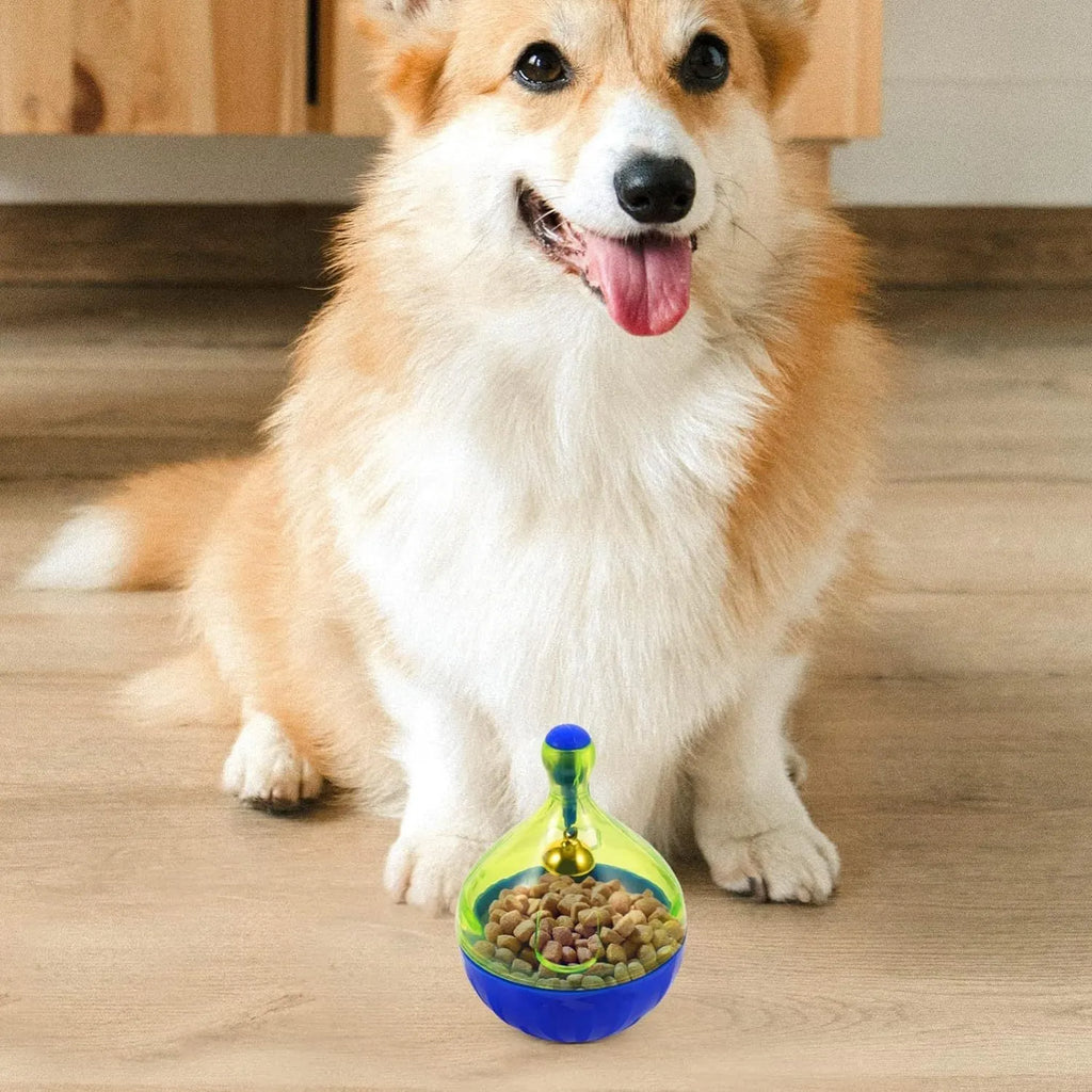 Blue and green tumbler-shaped interactive treat dispenser toy for dogs and cats on a wooden floor.