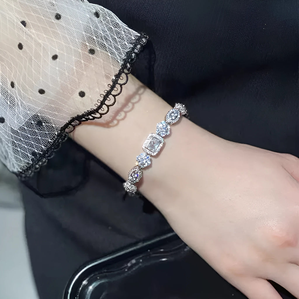 Women's geometric silver bracelet with zircon stones on a white background.