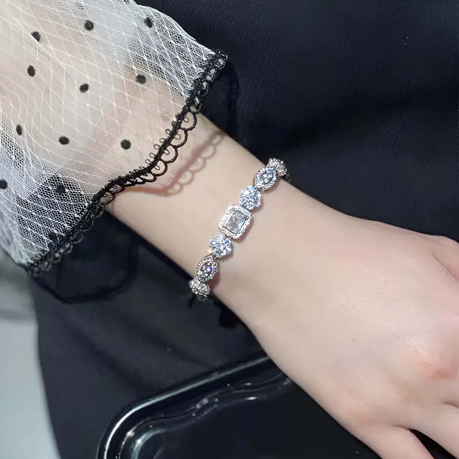 Women's geometric silver bracelet with zircon stones on a white background.