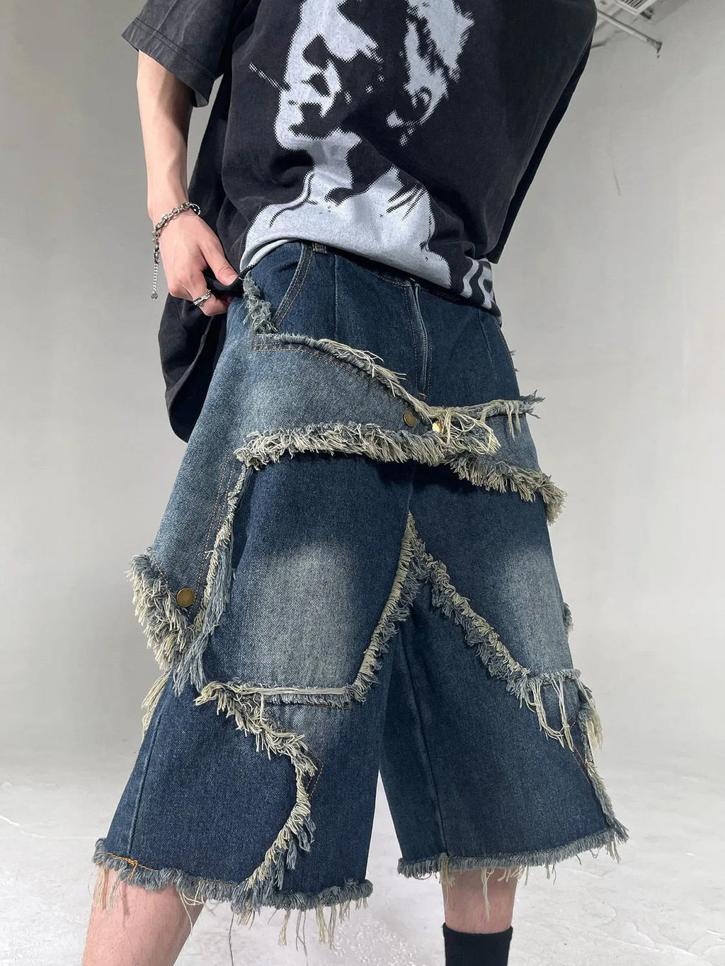 Blue denim shorts with frayed five-pointed star detailing and loose retro styling