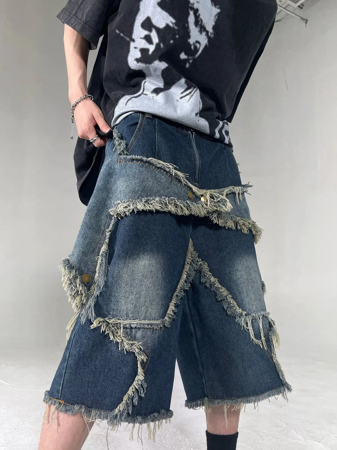 Blue denim shorts with frayed five-pointed star detailing and loose retro styling