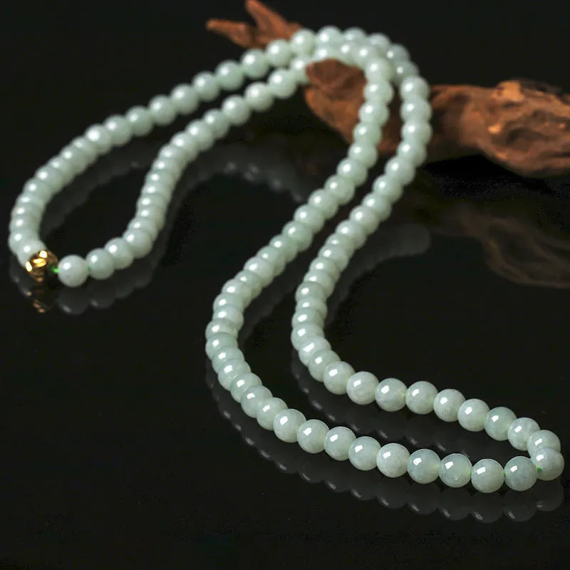 Adjustable necklace with a round white and green jade bead on a silver chain.