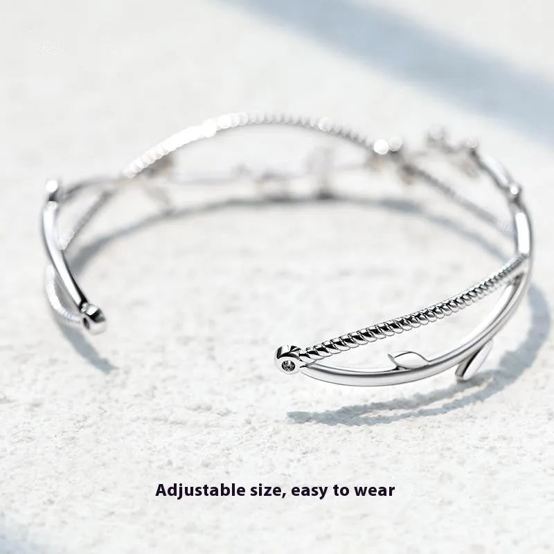 Cross twisted white gold electroplated bracelet with tree charm on copper base.