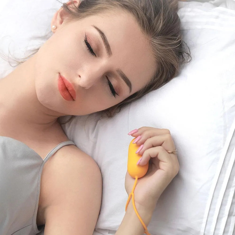 Handheld microcurrent sleep aid device with round control button in grey, green, or orange colours