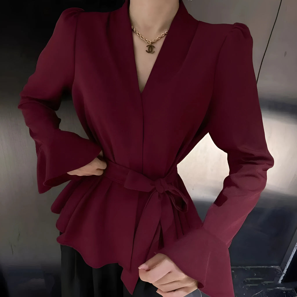 Women's black shirt with an irregular collar and long bell sleeves on a model.