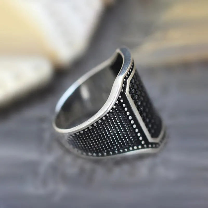 Black alloy ring with copper inlay and zircon stone, shown on a finger, size range 7 to 13.