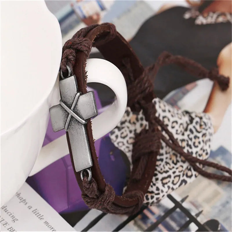 Brown leather cross bracelet with first layer cowhide and alloy accents on a neutral background