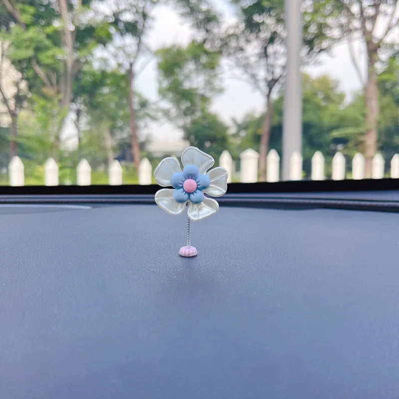 Small colourful plastic swing car decoration for dashboard or mirror.