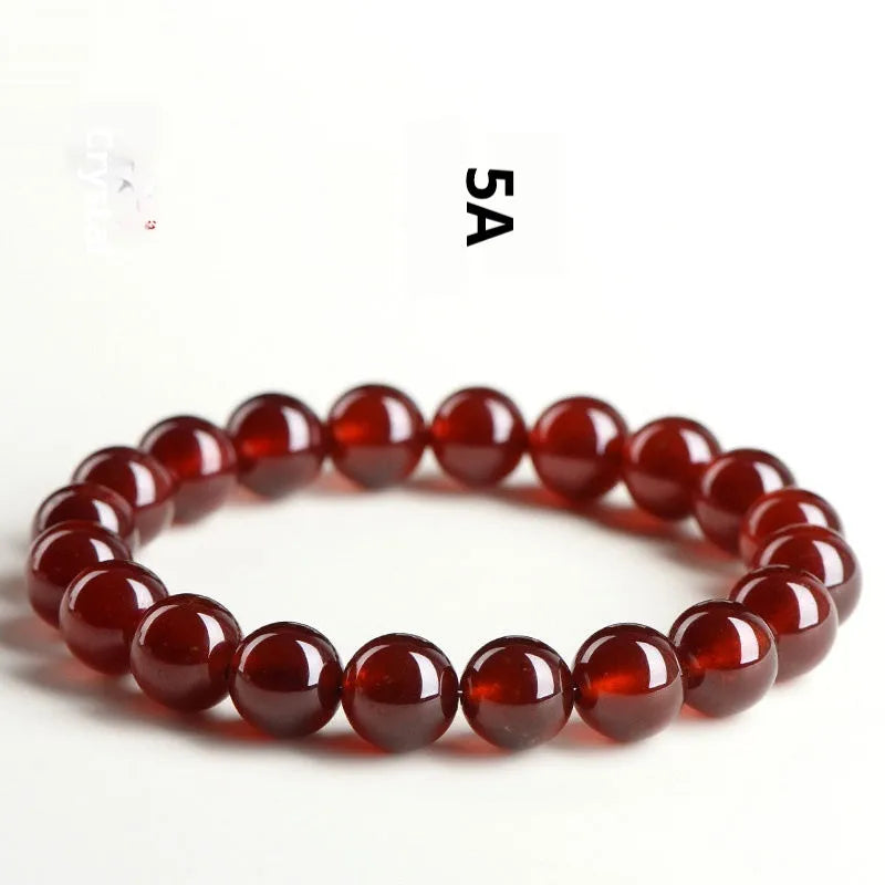 Close-up of a natural orange red garnet crystal bracelet in a unisex retro style with Ruyi design elements.