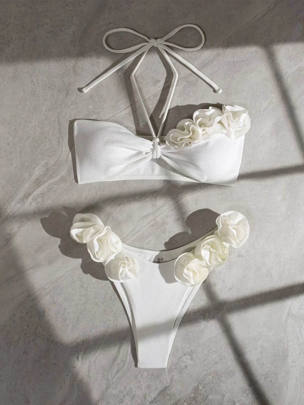 White halter bikini with three-dimensional flower pattern and lace-up detailing