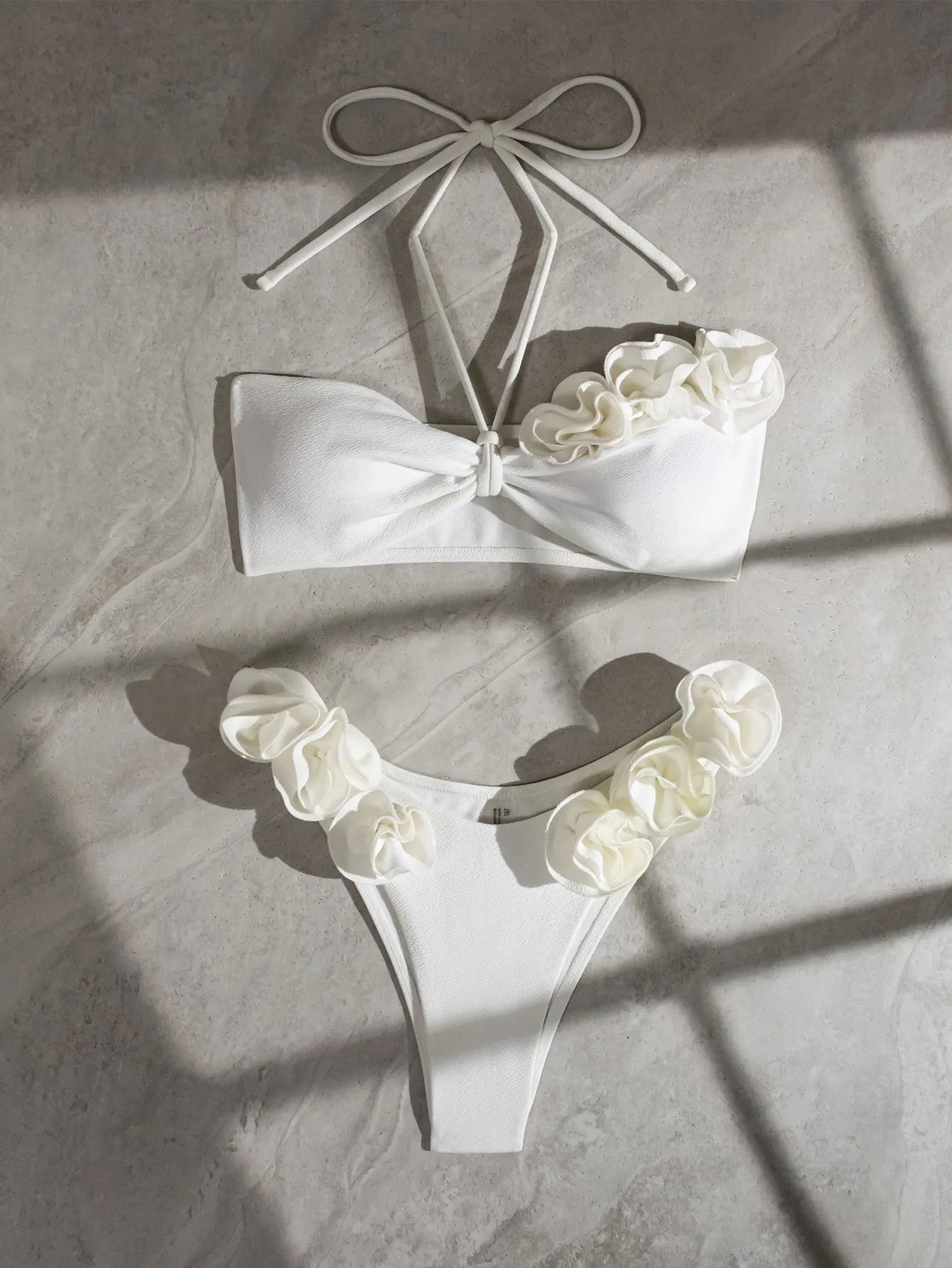 White halter bikini with three-dimensional flower pattern and lace-up detailing