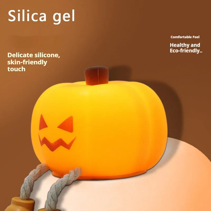 Soft orange silicone pumpkin-shaped night light with a warm glowing face on a table.