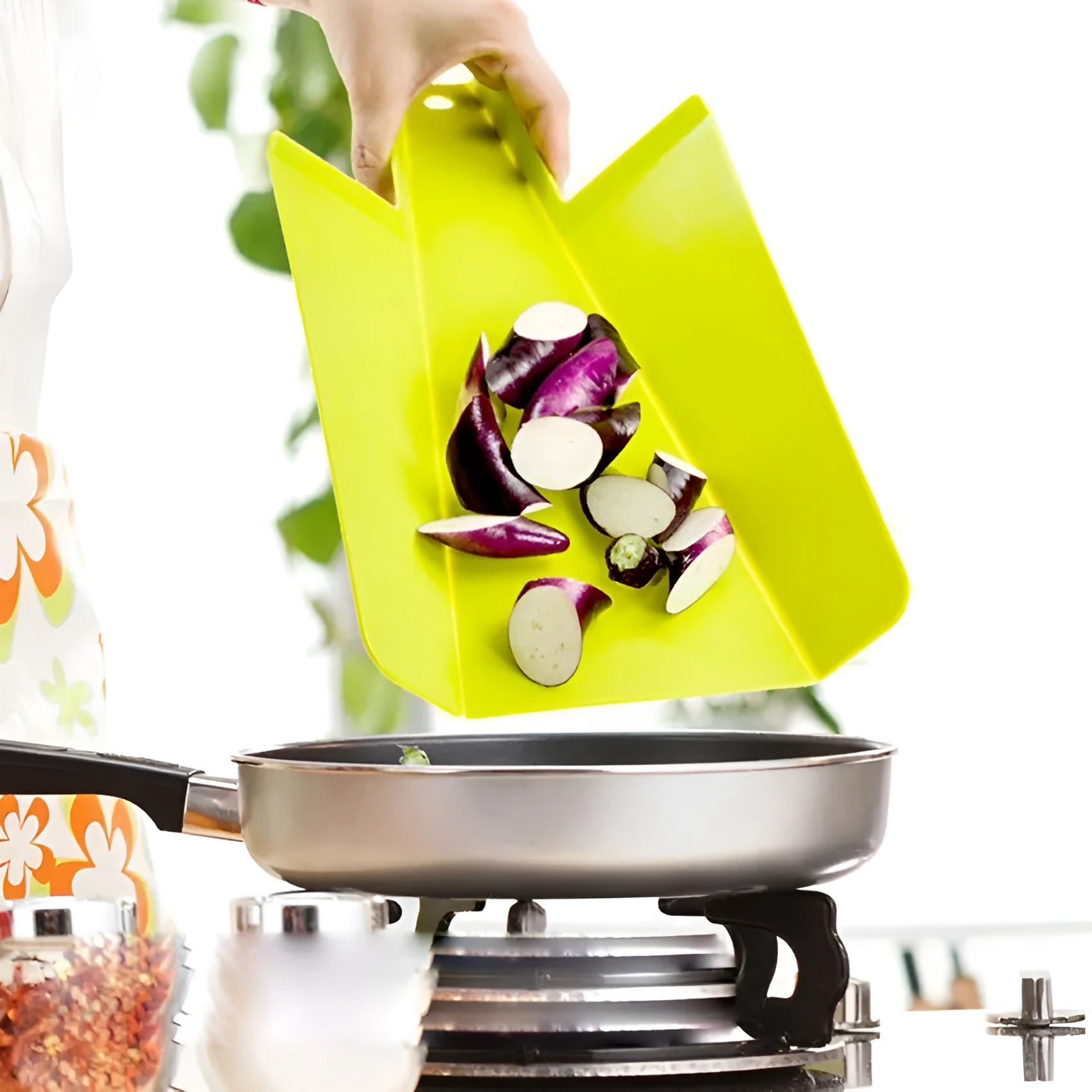 Green folding plastic cutting board with non-slip texture and hanging hole on kitchen countertop