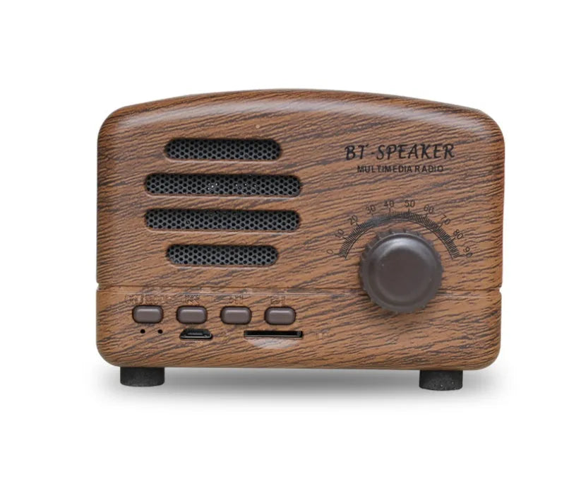 Compact vintage wood finish Bluetooth speaker in black, pink, or wood grain colour on a wooden surface.