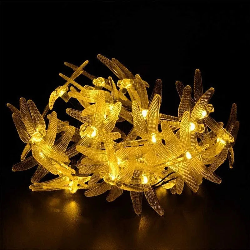 Five-metre solar-powered outdoor string lights with 30 warm white dragonfly-shaped LEDs and a separate solar panel on a spike.