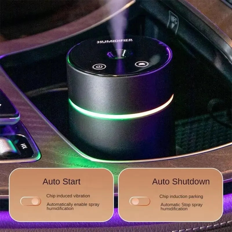 Compact aluminium car humidifier diffuser with colourful light and USB cable on a desk.