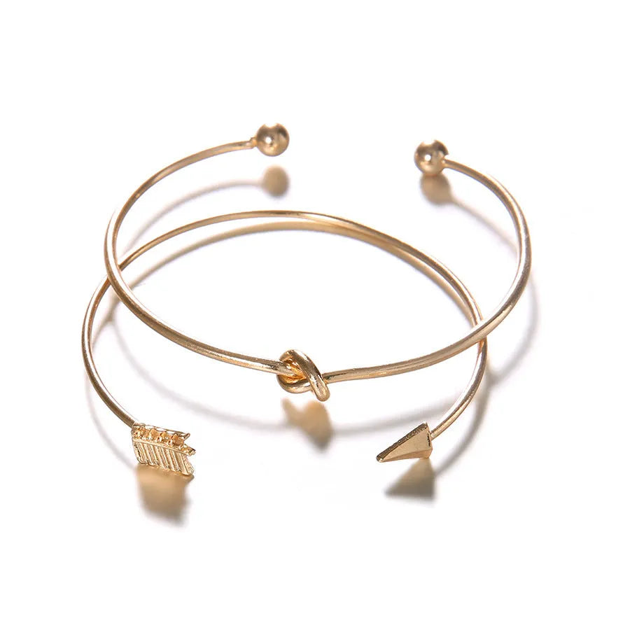 Gold vintage cuff bracelet for women with an arrow design and knotted detail.