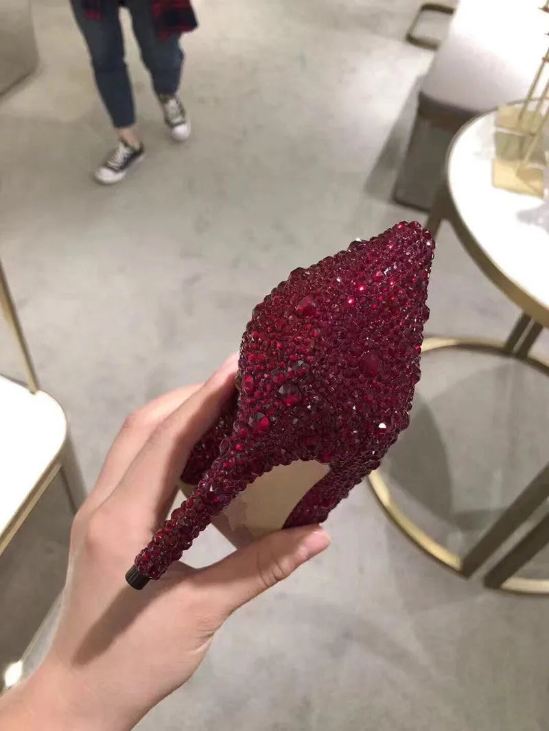 Women's gold stiletto high heel with pointed toe, rhinestone decorations, and a bow.
