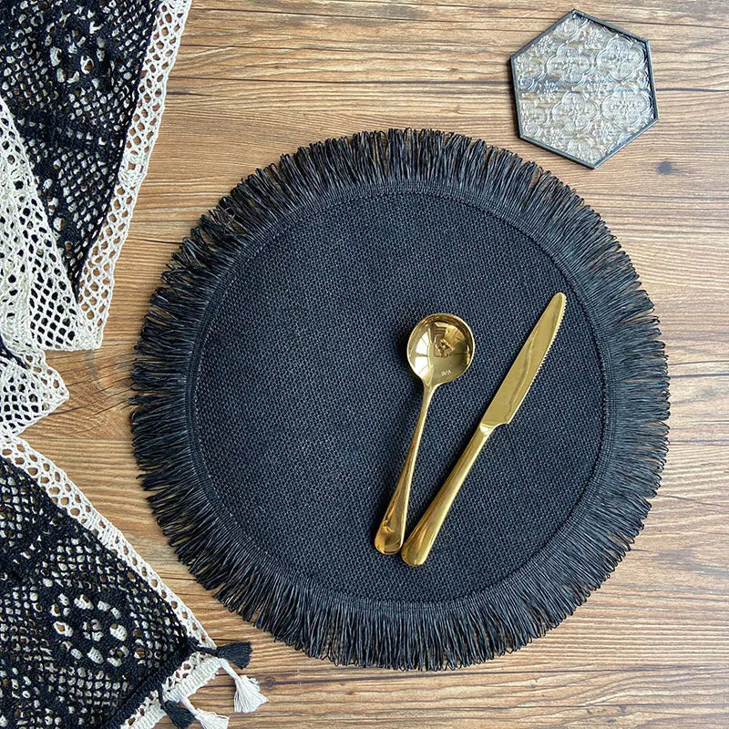 Handwoven round jute placemat with tassel edge in original hemp colour on a wooden table