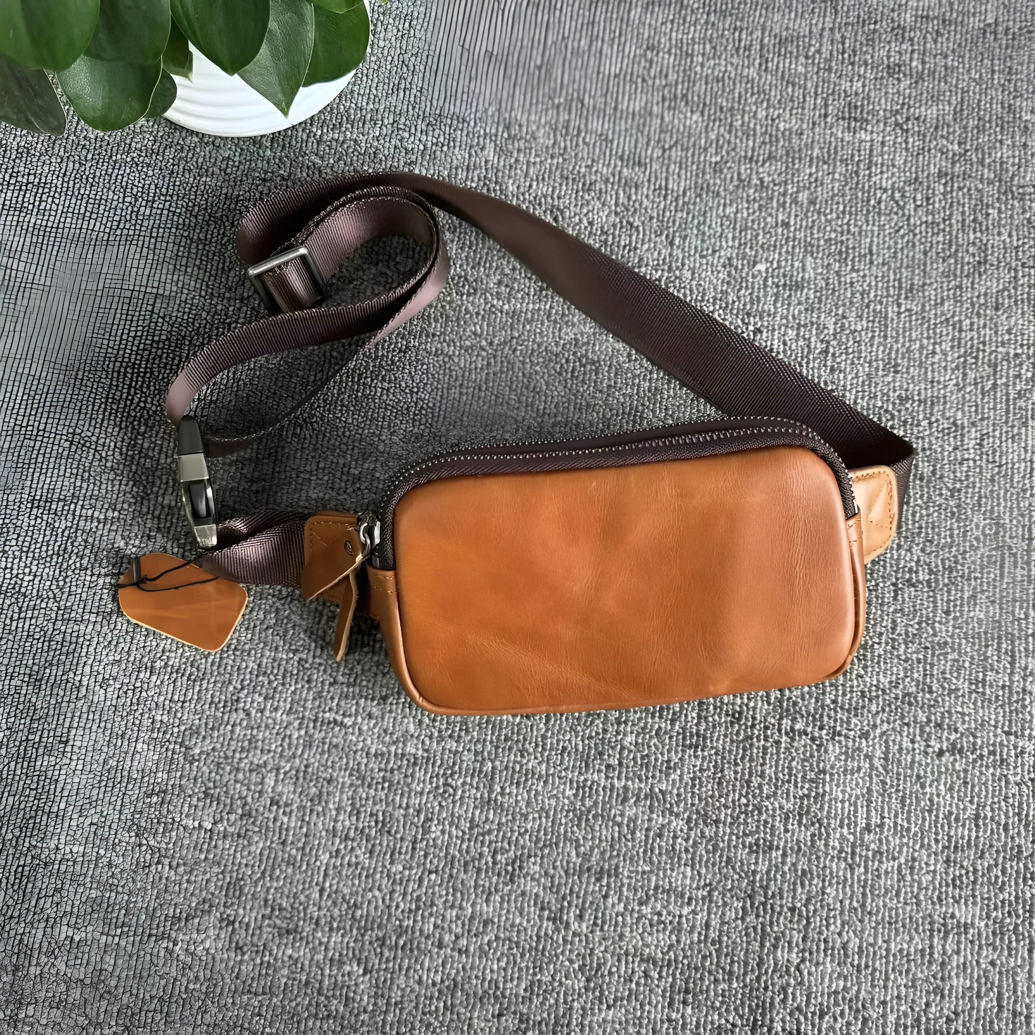Men's small leather crossbody bag in black showing 17cm width dimensions