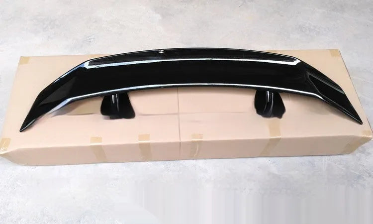 Universal punch-free car tail wing spoiler in ABS plastic shown in bright black and carbon pattern finishes.