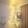 Flexible willow vine Christmas garland with birch bark texture and warm white LED lights extended along wall