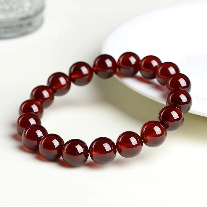 Close-up of a natural orange red garnet crystal bracelet in a unisex retro style with Ruyi design elements.