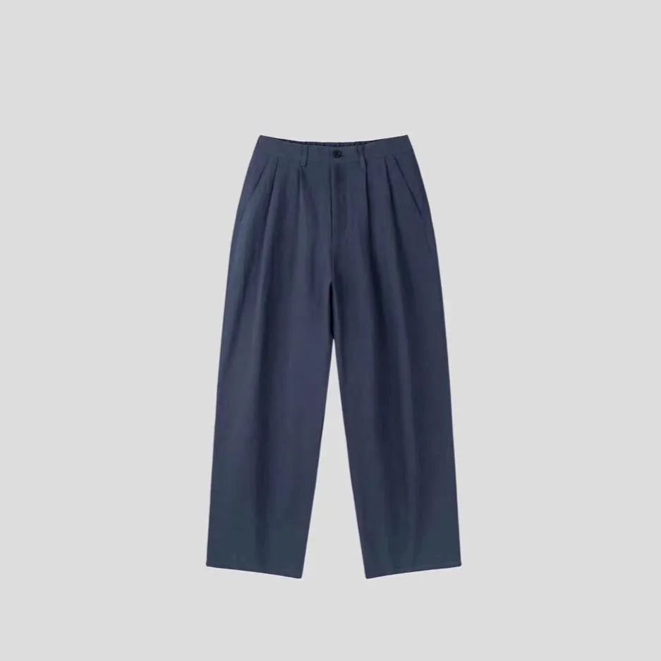 Men's loose-fit apricot cotton linen trousers with a mid-waist and pencil leg opening.