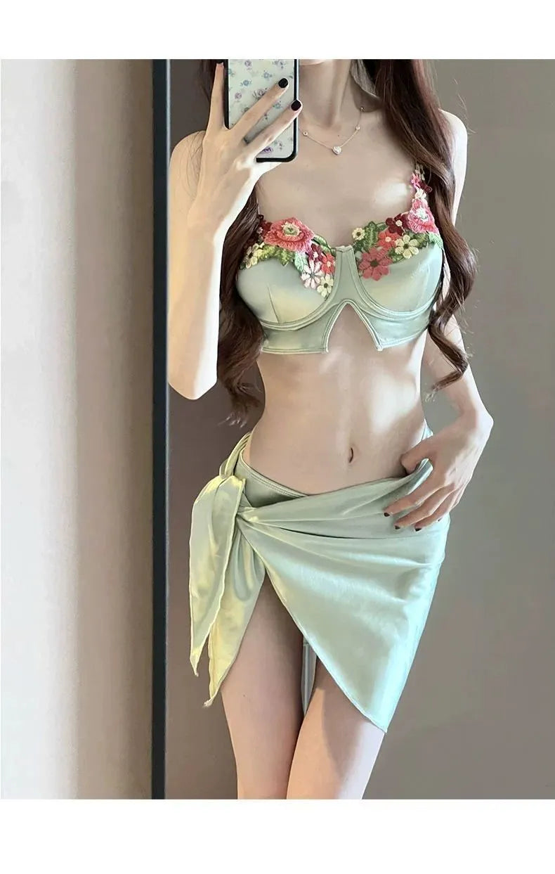 Green women's bikini three-piece set with triangle top, briefs, and matching skirt