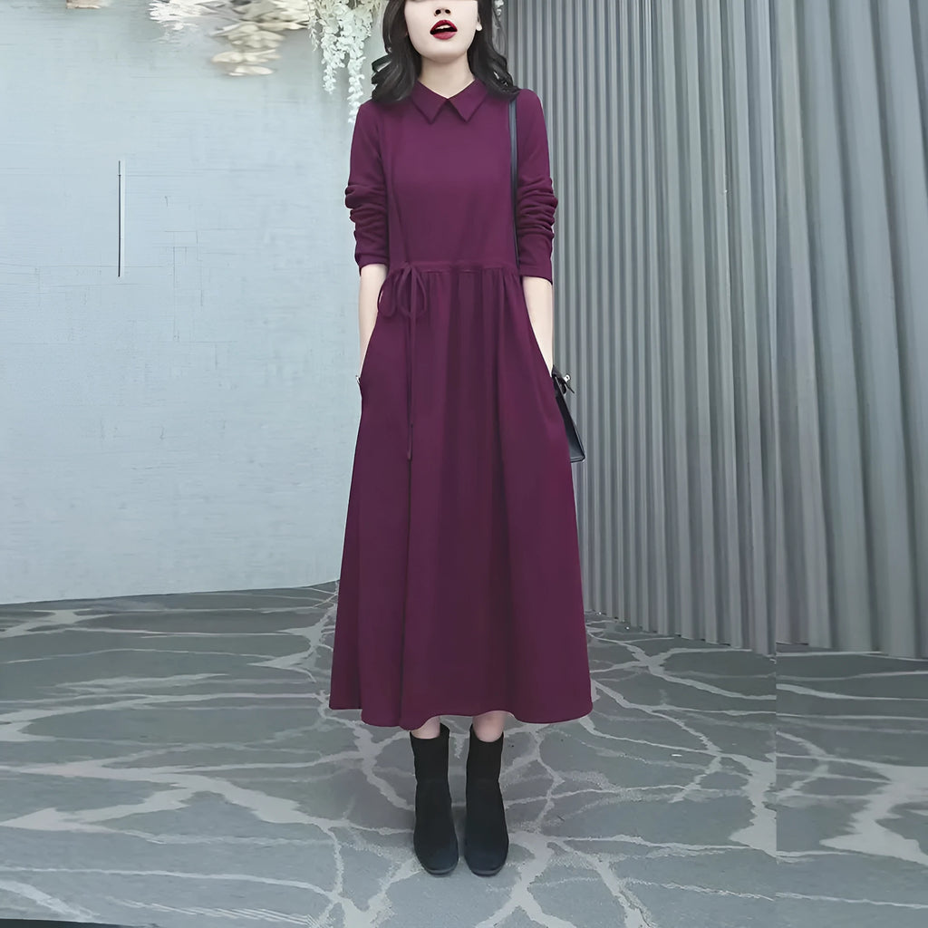 A purplish red plus size long sleeve midi dress for women, shown in an urban style.