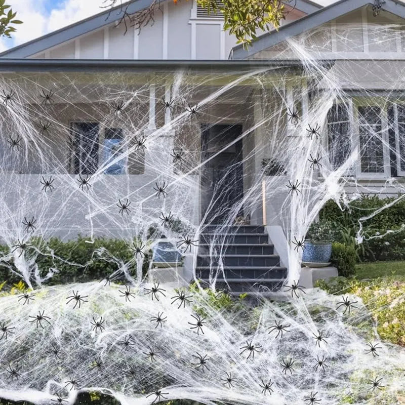 Halloween cotton spider web decoration with white plastic spiders on a dark background