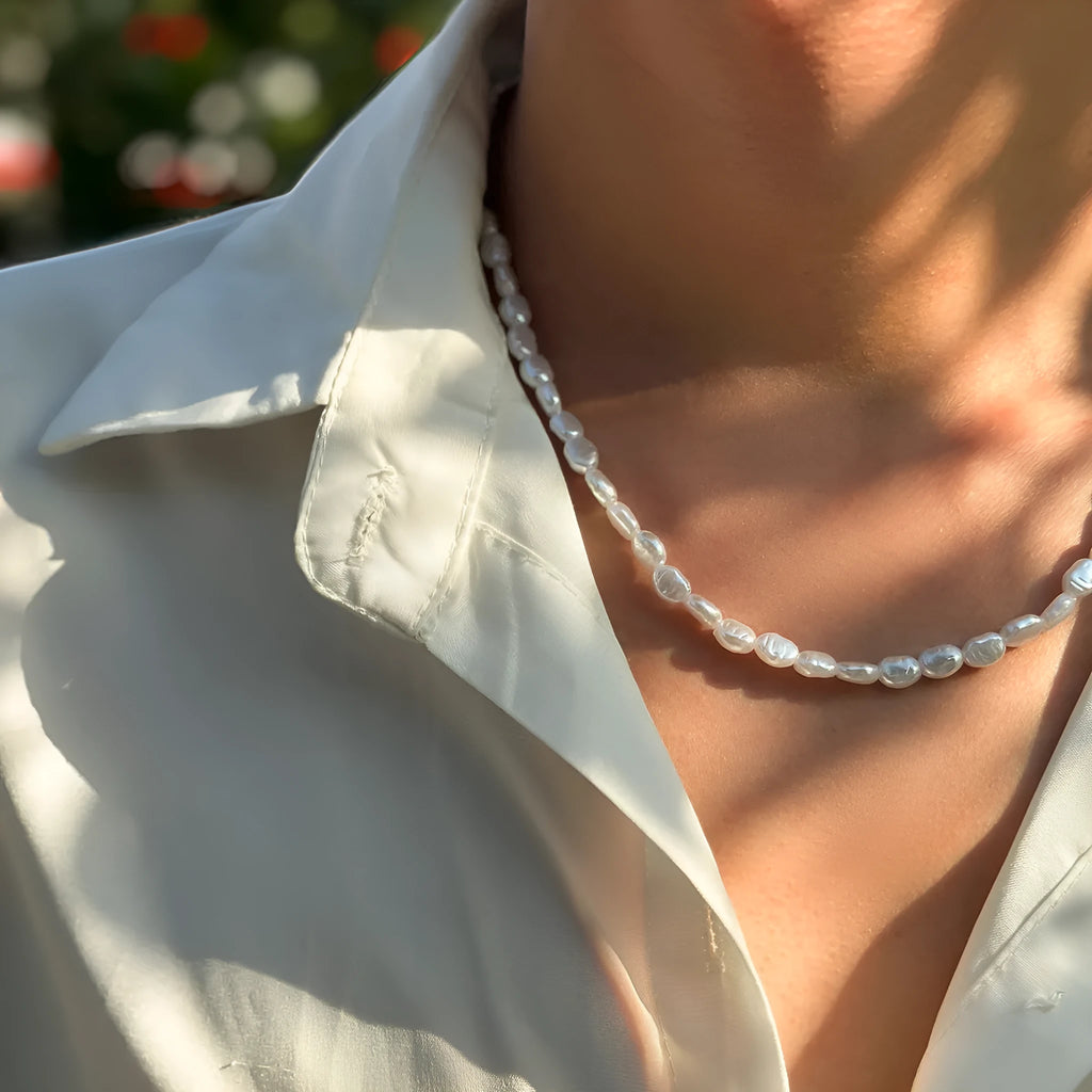 White U-shaped men's imitation pearl necklace with shellfish pendant on clavicle