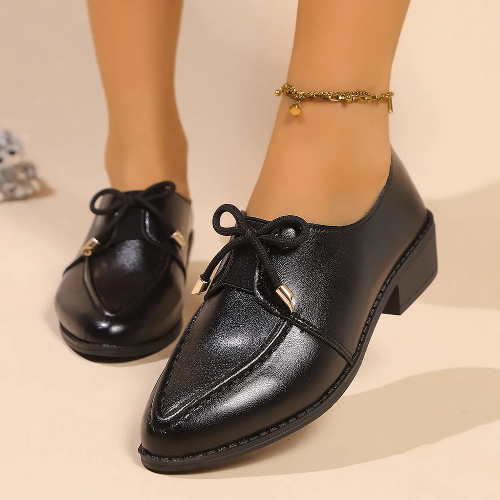Women's pointed-toe PU slip-on shoe with a decorative bow on a rubber sole.