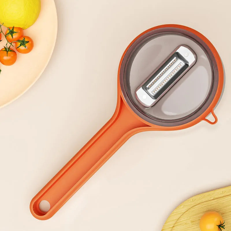 Light green plastic kitchen peeler with built-in storage bucket and scraper function.