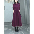 A purplish red plus size long sleeve midi dress for women, shown in an urban style.