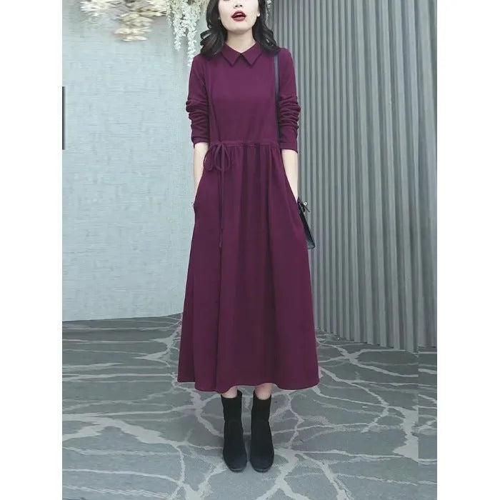 A purplish red plus size long sleeve midi dress for women, shown in an urban style.