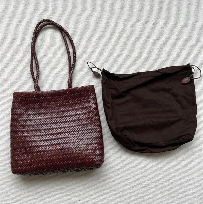 Brown handmade woven leather tote bag with a three-dimensional front pocket.