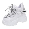 Women's white and black platform tennis shoes with mesh upper and cross-strap.