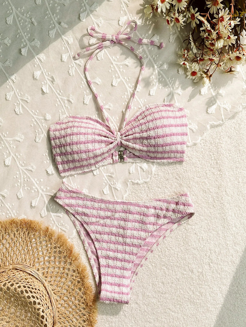 Women's pink and black striped printed bikini swimsuit on a hanger.
